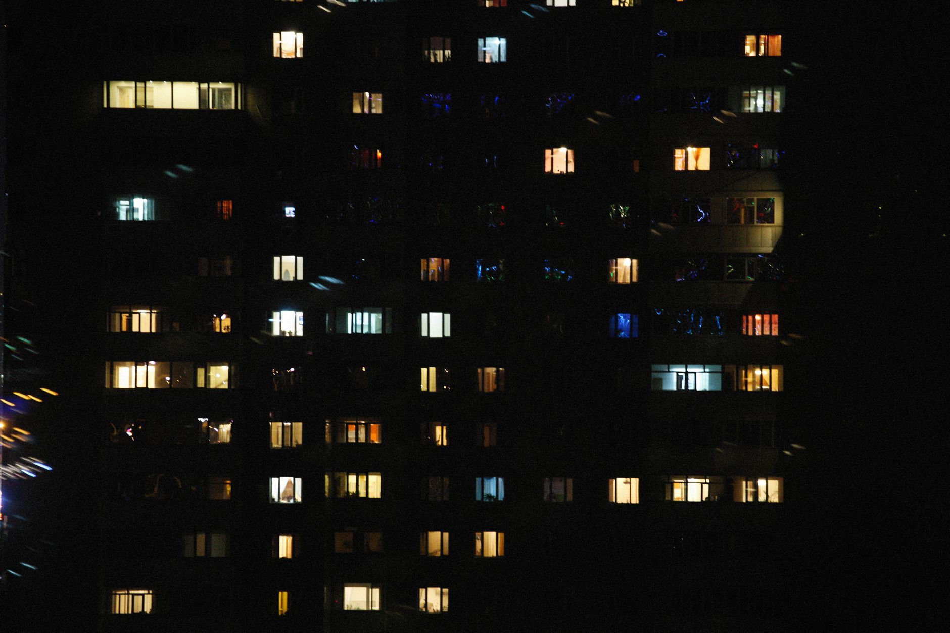 Bloque de viviendas de noche con parte de las ventanas iluminadas.