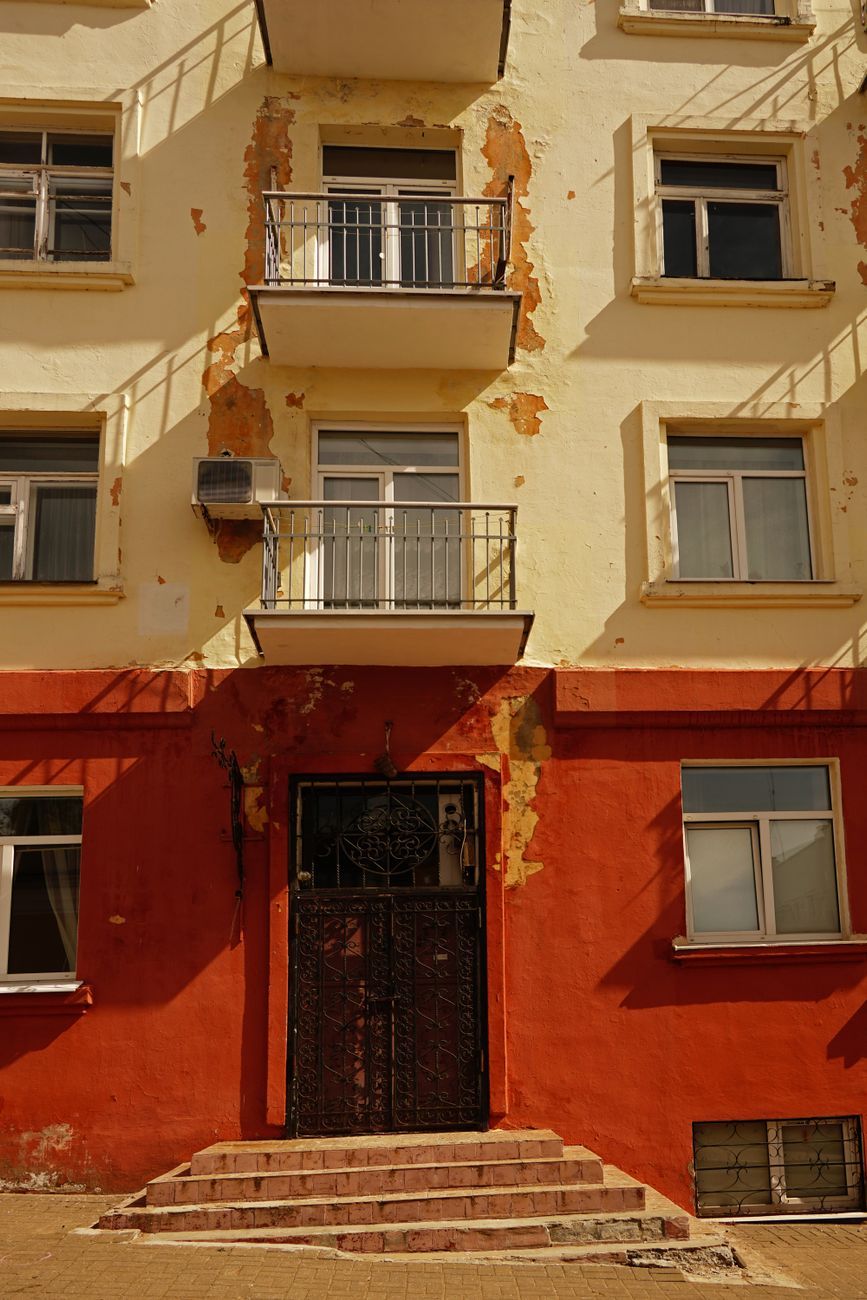 Fachada de un bloque de viviendas con balcones corridos y pintura de varios colores.